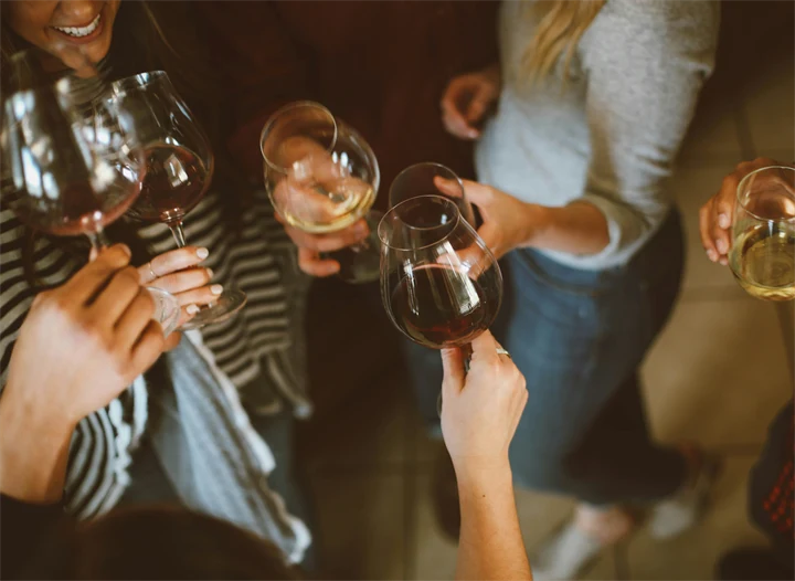 Bild på en grupp människor som skålar med vinglas.