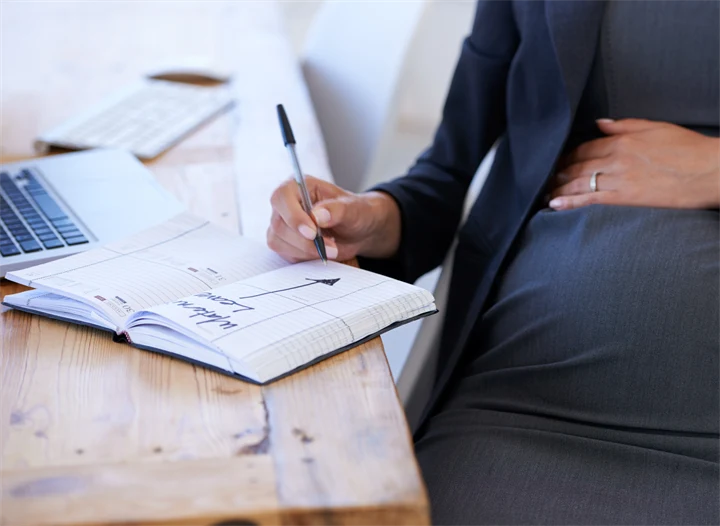 Gravid kvinna planerar för föräldraledighet. 